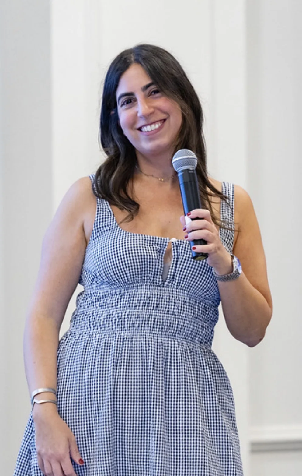 Sheena smiling and holding a microphone